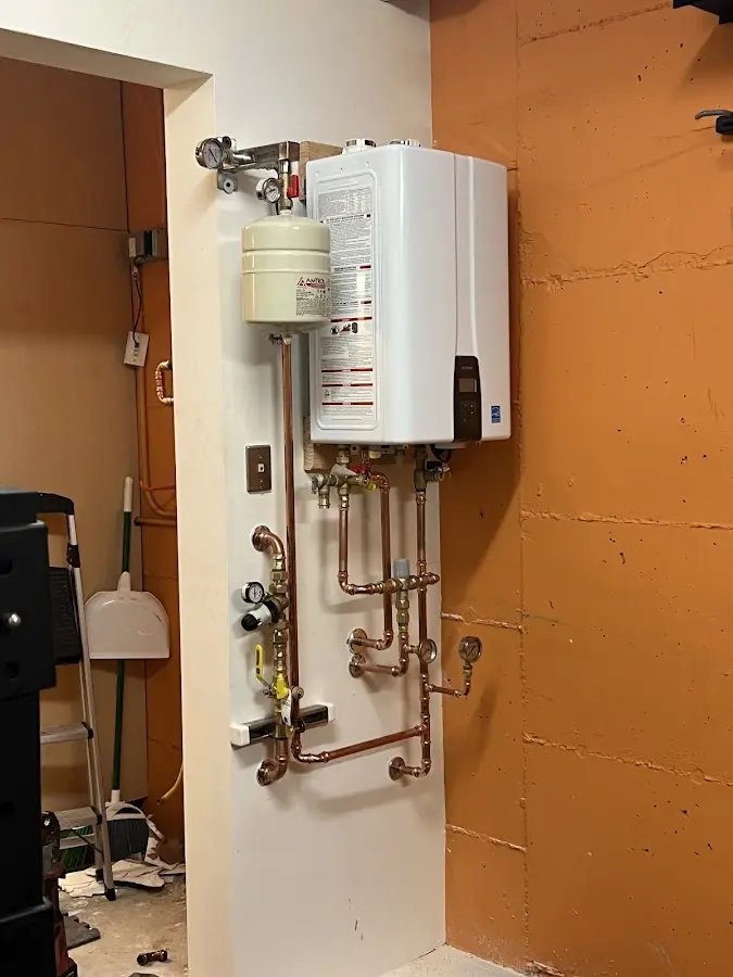 Plumbing technician inspecting water heater connections in Walker Mill